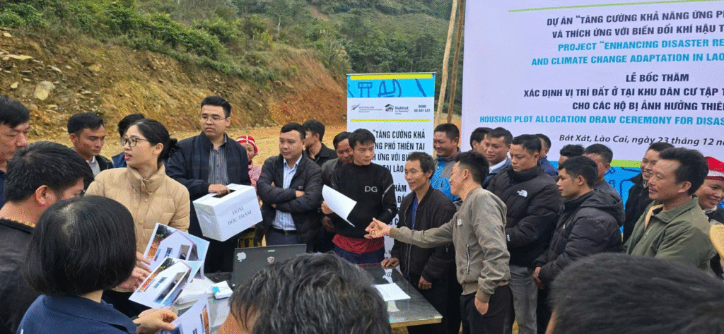 Beneficiary households look into the project's house model